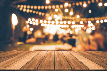 wooden table in front of abstract blurred restaurant lights background