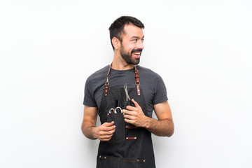 Fototapeta na wymiar Barber man in an apron with arms crossed and happy
