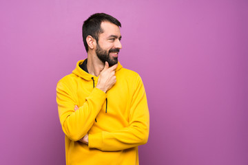 Fototapeta premium Handsome man with yellow sweatshirt looking to the side