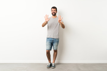 Fototapeta na wymiar A full-length shot of handsome man with beard counting nine with fingers