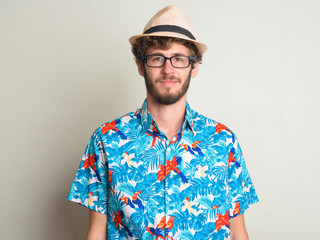 Face of young bearded tourist man with curly hair ready for vacation