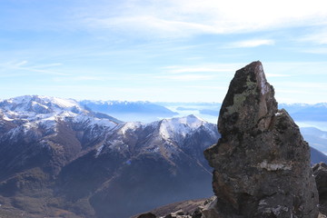 Fototapeta na wymiar Single Stone staring out upon snow tipped mountains 
