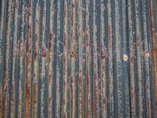 Abstract and closeup of old, rusty and cracked aluminium zinc wall with vertical striped pattern.