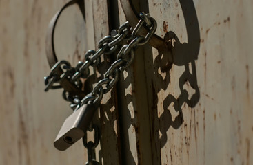 Old metal chain with a strong chain fastened with a lock