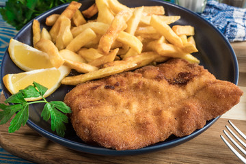 A piece of fried cod with fries on a plate.