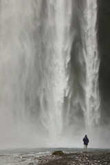 Tourist at Skogafoss Waterfall, famous natural landmark in Iceland, Europe