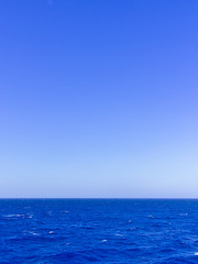 Obraz premium Vivid blue sea and sky, vertical image with copy space.