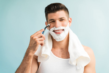 Happy Young Hispanic Man Styling Against Turquoise Background