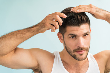 Portrait Of Attractive Latin Man Setting Hairstyle