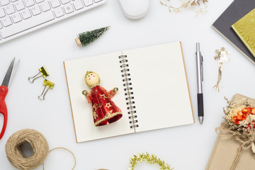 Top view of blank notebook on white  background on office desk with Christmas decorations. Mockup notebook for wish list or to do list. Flat lay with copy space.