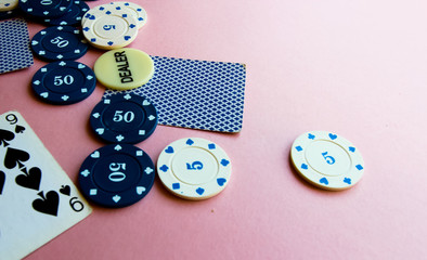 Poker chips and cards on a pink background. The game of poker. Chip dealer. Place for text.