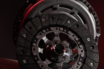 Two circle brake discs on dark red background. Disc brake rotors are metal discs that work together with the brake pads and calipers to slow the vehicle.