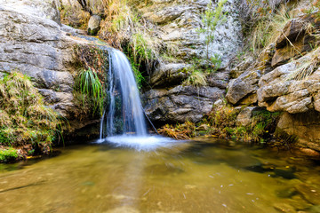 Fototapeta premium Small waterfall in a stream in the mountains of Madrid, right in La Pedriza