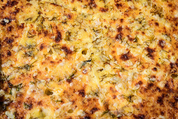 Top view of freshly homemade cheese cake with dill, on display for sale at a street food market, soft focus