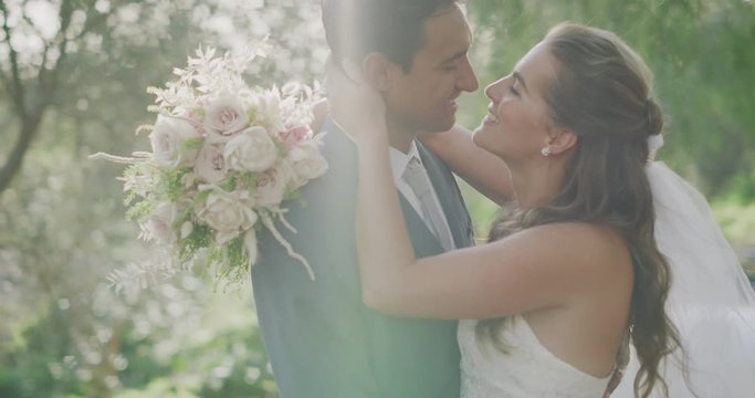 Intimate scene of happy diverse couple on their wedding day kissing in nature, amazing marriage moment