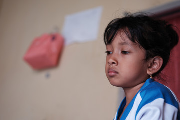 Little Asian girl showed sad expression. Cute Indonesian kid. 