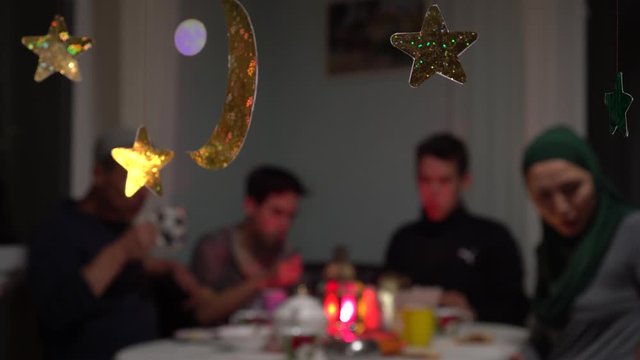 Muslim family eating festive dinner at home. Mawlid or Mawlid al-Nabi al-Sharif is the observance of the birthday of Islamic prophet Muhammad