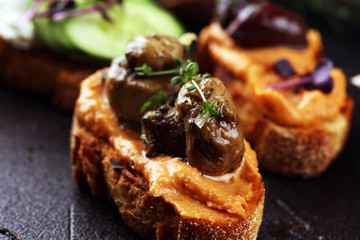 Assorted bruschetta with various toppings. Appetizing bruschetta or brie crostini. Variety of small sandwiches. Mix bruschetta on table