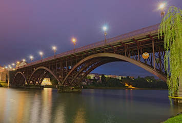 Scenic morning view of illuminated Old Bridge (also named the State) over Drava River. Selective focus with wide angle lens. Concept of landscape and nature. Lower Styria, Maribor, Slovenia