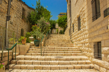 Fototapeta premium Eastern colorful back street stairs alley way between ancient stone buildings in summer warm season clear weather time 