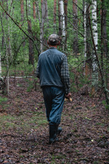 Man walking alone in magical dark green colored foggy wild forest landscape.