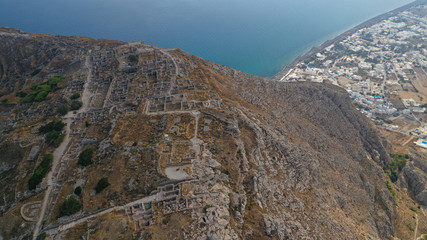 Fototapeta na wymiar Aerial drone photo of iconic archaeological site of ancient Thera or Thira built uphill with amazing views to Kamari and Perissa beaches and seaside villages, Santorini island, Cyclades, Greece