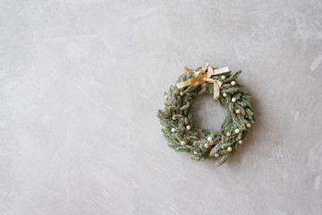 Beautiful delicate Christmas wreath on the gray wall. Copy space