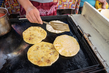 The lady is populating Salvadoran corn.