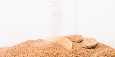 Cryptocurrency gold coins are strewn with sand.