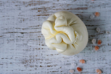 Burrata, Italian fresh cheese made from cream and milk of buffalo or cow. Close-up. Delicate delicacy on a white background.
