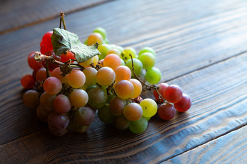 Ripe green and red grapes on a wooden table