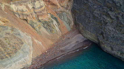 Aerial drone photo of secluded beach and volcanic black seascape near Akrotiri lighthouse, Santorini island, Cyclades, Greece
