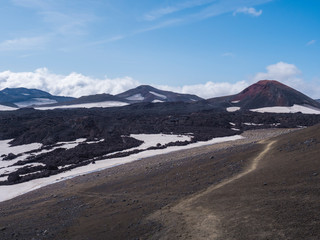 Red and black volcanic Iceland landscape at Fimmvorduhals hiking trail with glacier volcano lava field, snow and magni and mudi hill, createed by eruption of Eyjafjallajokull in 2010 which affected