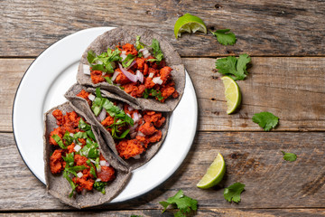 Mexican chorizo tacos with blue corn tortillas on wooden background - obrazy, fototapety, plakaty