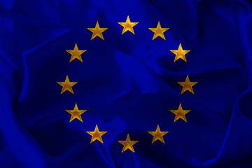 close-up photo of beautiful colored stylized European Union flag, symbol of united Europe on textured fabric, concept of tourism, emigration, economy and politics, close-up