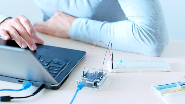 Computer programming. Software development. IT engineer building project with microcontroller.