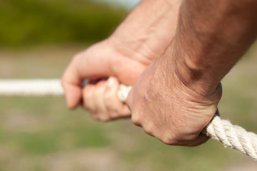 strong male hands hold the rope