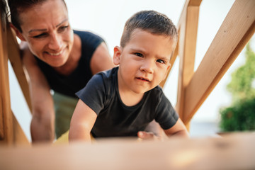 Toddler boy crawling up the stairs at tree house