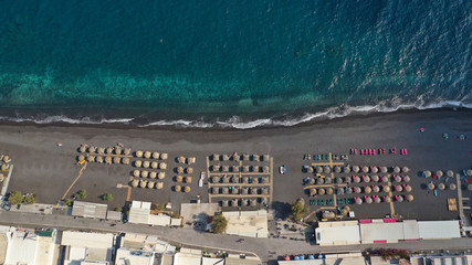 Aerial drone top down photo of famous seaside village and organised with sun-beds and umbrellas...