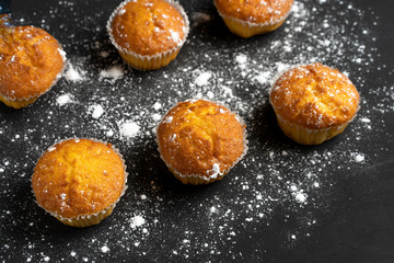 Appetizing muffins stand on a table top view. Traditional pastries on a dark background minimalism.