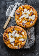 Cheesy autumn veggie flatbread. Pumpkin, sweet potato, red onion, mozzarella pizza on dark background, top view