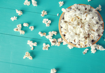 plate of popcorn on a blue wooden background, top view