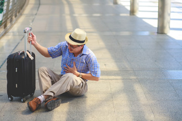 Elderly men are going to board the plane. He had a painful facial expression and then fell and tightened his chest as if he had a heart disease.
