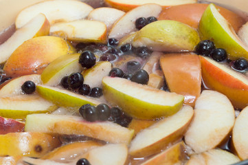 Apples and black currant berries in compote, cooking process
