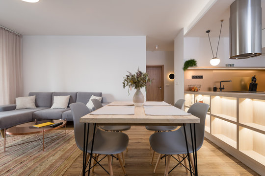 Dining table between kitchen and living room in contemporary apartment