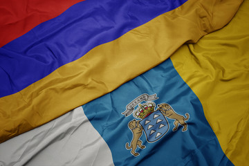 waving colorful flag of canary islands and national flag of armenia.