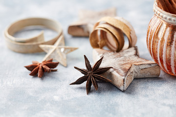 Star anise and wooden Christmas Star on bright wooden background. Close up. 
