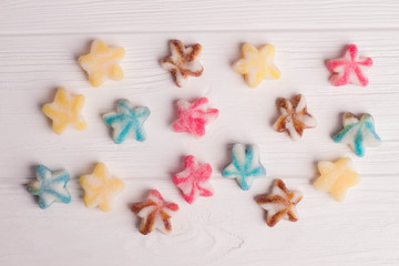 Colorful sugar coated candies on a wooden background. Composition from multicolored sweets on white wood.