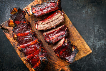 Barbecue chuck beef ribs with hot marinade as top on a wooden cutting board with copy space right - obrazy, fototapety, plakaty