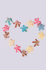 Heart made from colorful sugar sweets. Romantic background with delicious candies on white background. Love and romance.